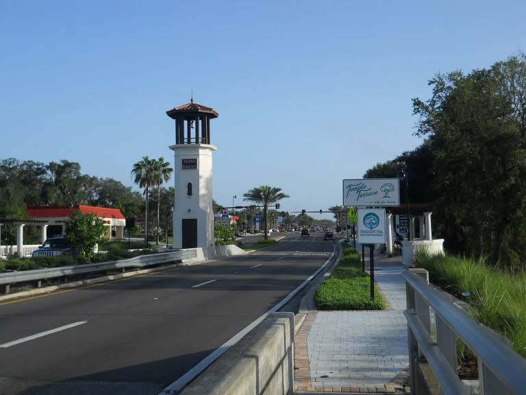La torre de entrada de la calle 56 que recibe a los conductores en Temple Terrace, con palmeras y un letrero de la ciudad